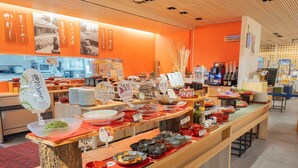 Buffet-alue, jossa on tarjolla monipuolinen valikoima ruokia, sekä puinen palvelutiski.