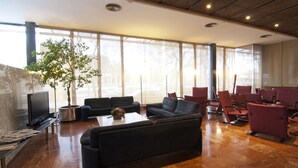 A spacious lobby with a large seating area, a coffee table, and a television.