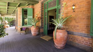 A brick building with green shutters and a covered porch.