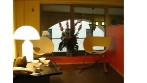 A room with a large window, a desk with a lamp, and a chair. - Albergo Verdi (Padova)