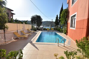 Alberca al aire libre, sombrillas en la alberca y camastros