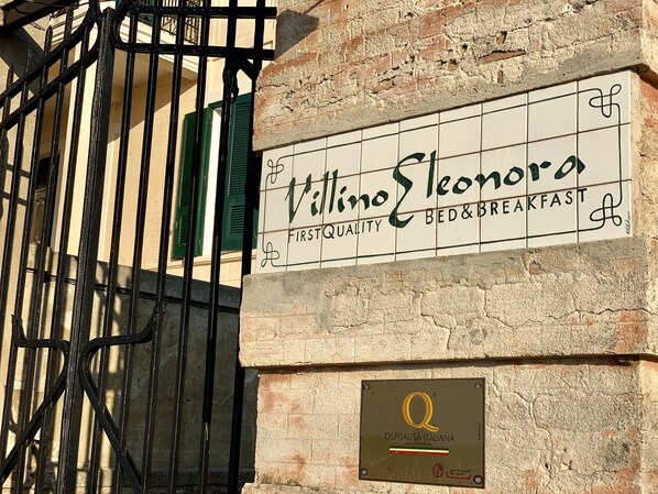 A sign for Villino Leonora, a bed and breakfast, with a plaque indicating it is a quality approved establishment. - Villino Eleonora & Spa (Parghelia)