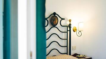 A bedroom with a metal bed frame, a bedside lamp, and a wall-mounted light fixture.