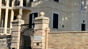 A historic building with a stone facade, multiple balconies, and a gated entrance. - Villino Eleonora & Spa (Parghelia)