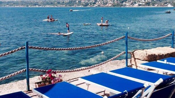 Vista al mar con sillas de descanso y una barrera de cuerda.