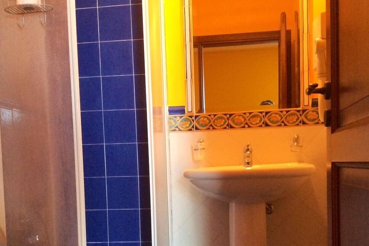 A bathroom with a toilet, a sink, and a shower area.
