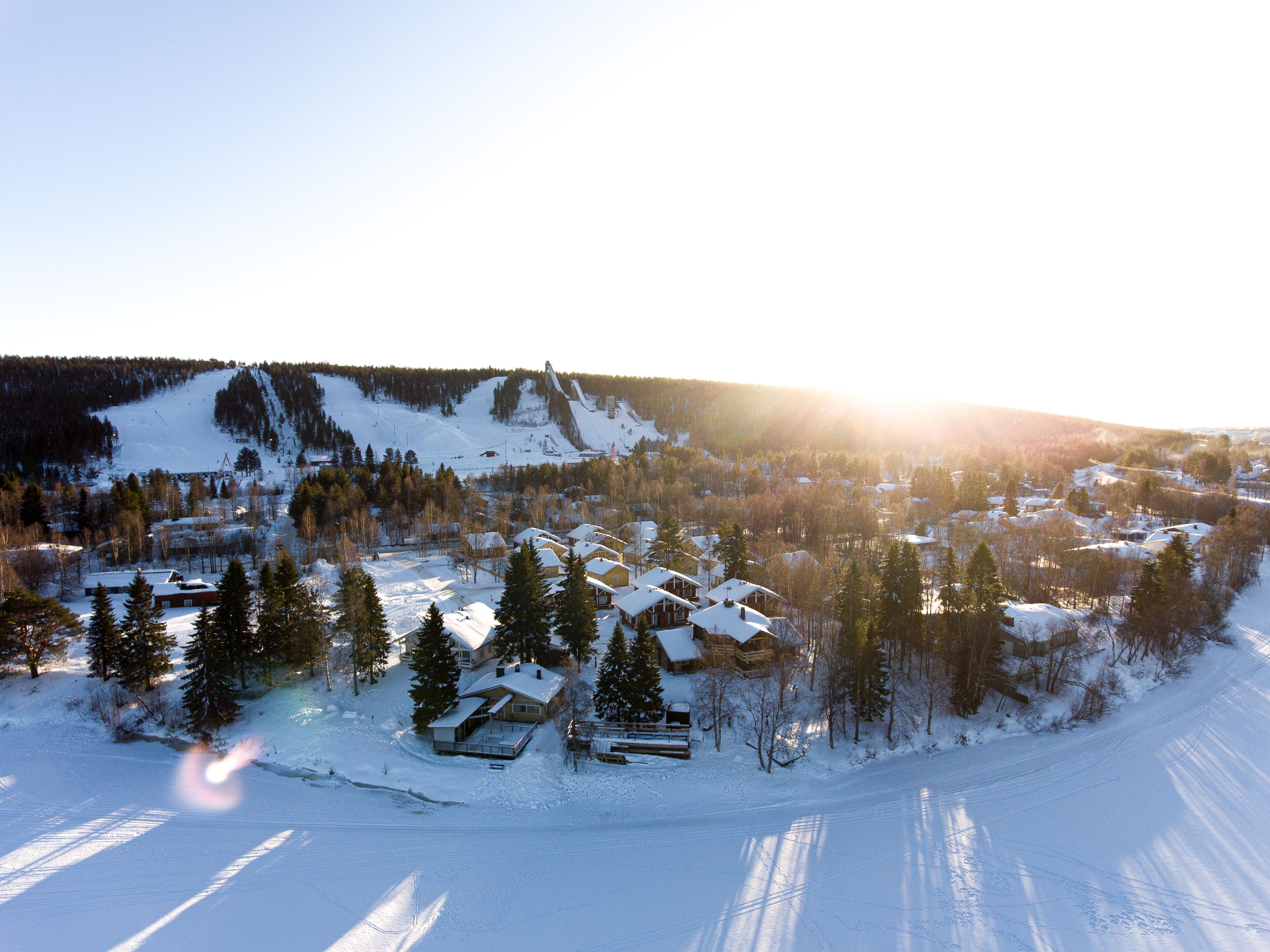 Un pueblo cubierto de nieve con casas y una pista de esquí.