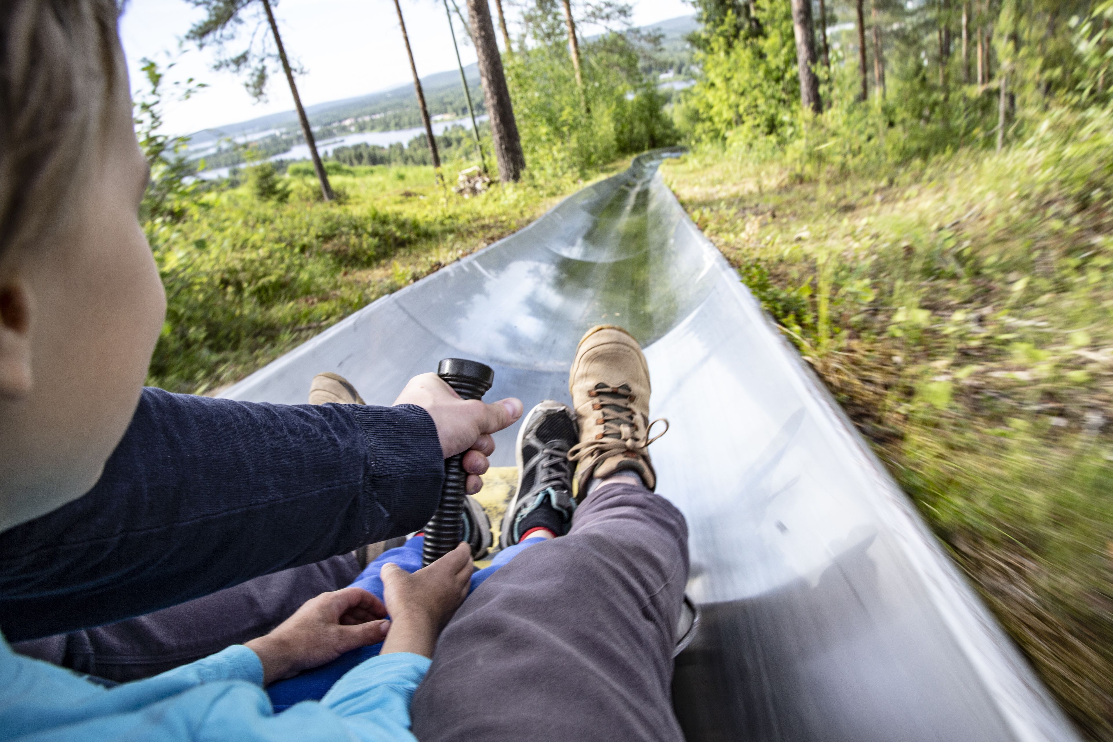 A person lying on a transparent tube, holding onto the tube's edges.