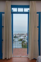 Un balcón con vista al mar y edificios.