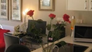 A modern kitchen with a chandelier, a dining table with chairs, a bowl of fruit, and a vase with flowers. - Navona Constantia Guest Cottage (Cape Town)