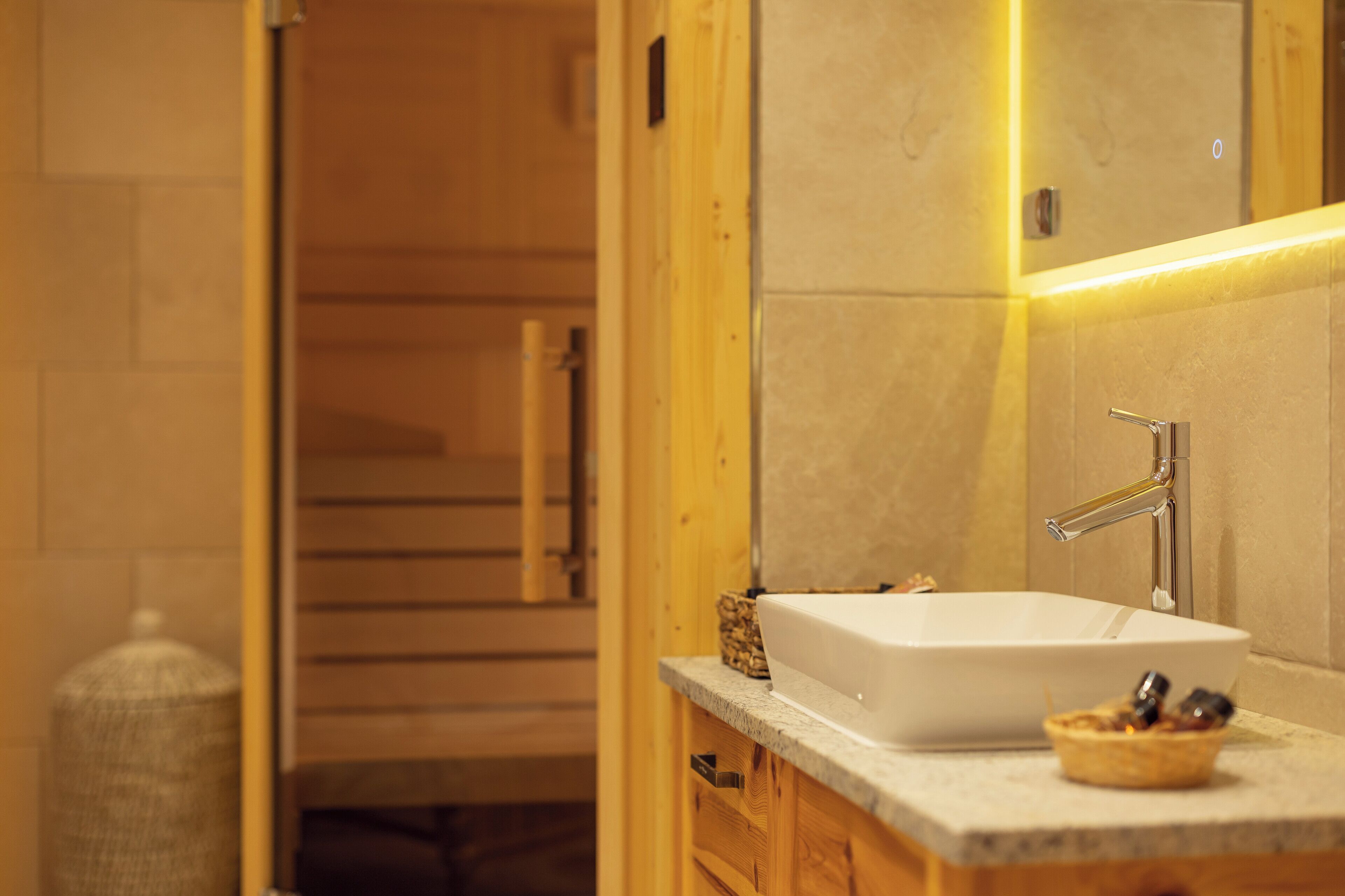 A bathroom with a white sink, wooden cabinets, and a mirror.