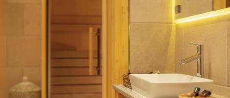 A bathroom with a white sink, wooden cabinets, and a mirror.