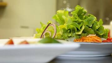 A plate of fresh salad with lettuce, carrots, and onions.