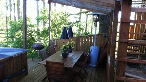 A wooden deck with a table and chairs, surrounded by a wooden fence and trees. - Mattisgården Bed & Breakfast (Klippan)