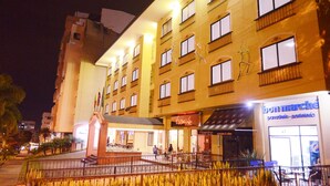 Ein Hotel mit mehreren Etagen, Balkonen und einem Innenhof mit Sitzgelegenheiten.