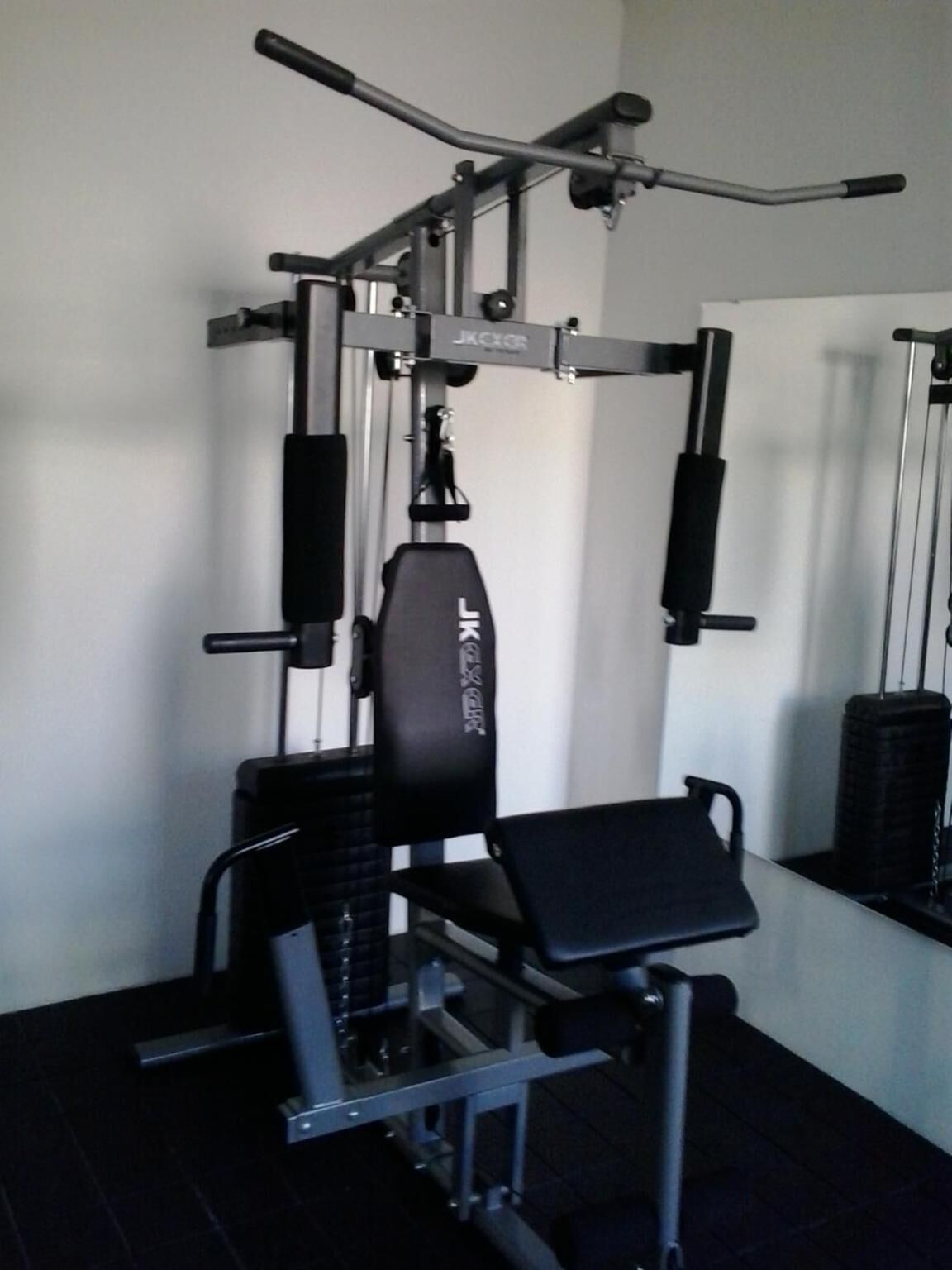 A gym with a squat rack, bench press, and a pull-up bar.
