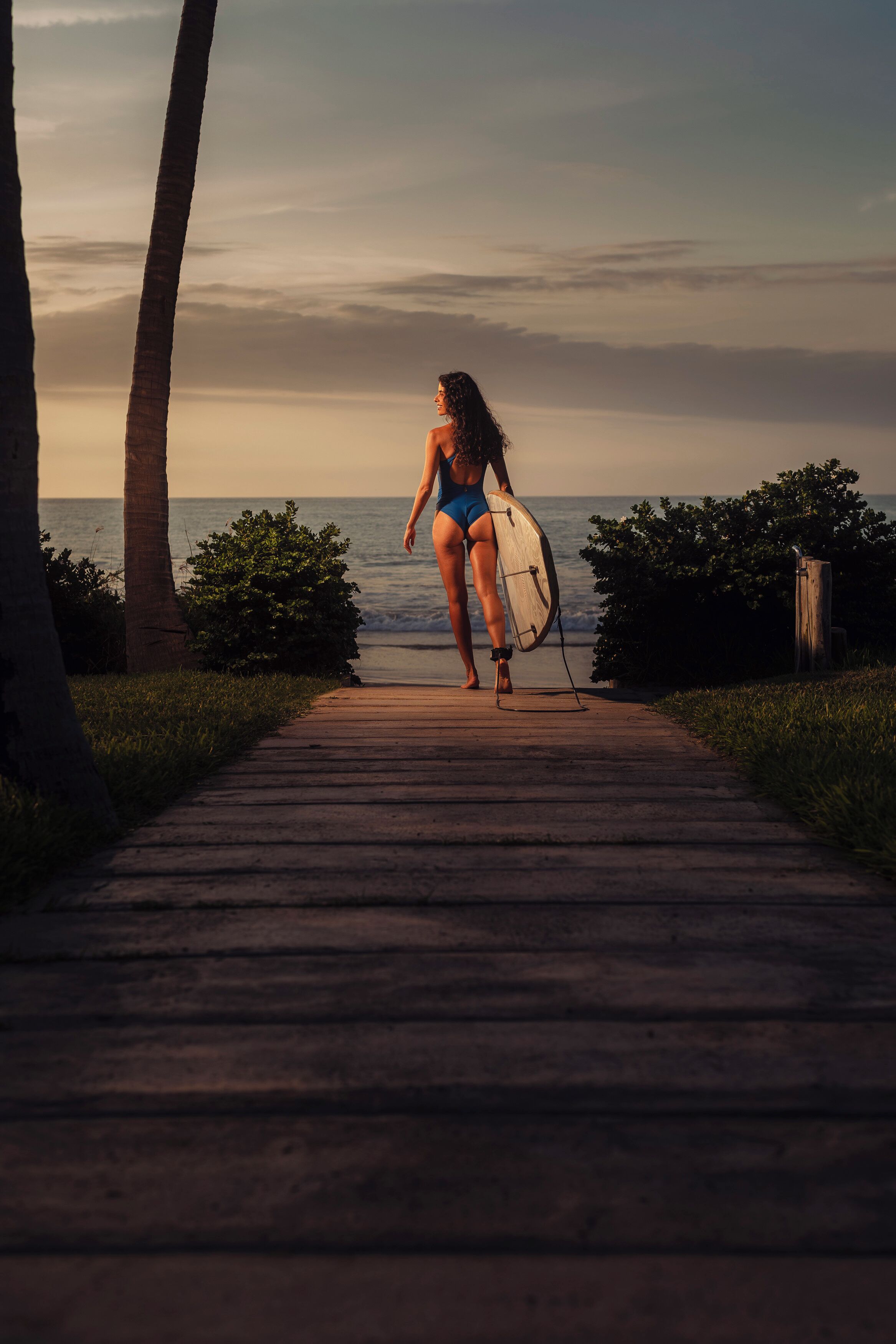 A pathway leading to the beach with palm trees and ocean views.