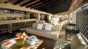 A bar area with a sofa, books, and glasses on a table.