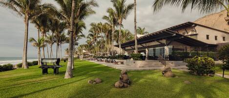 A resort with a pool area, palm trees, and a building with a modern design.