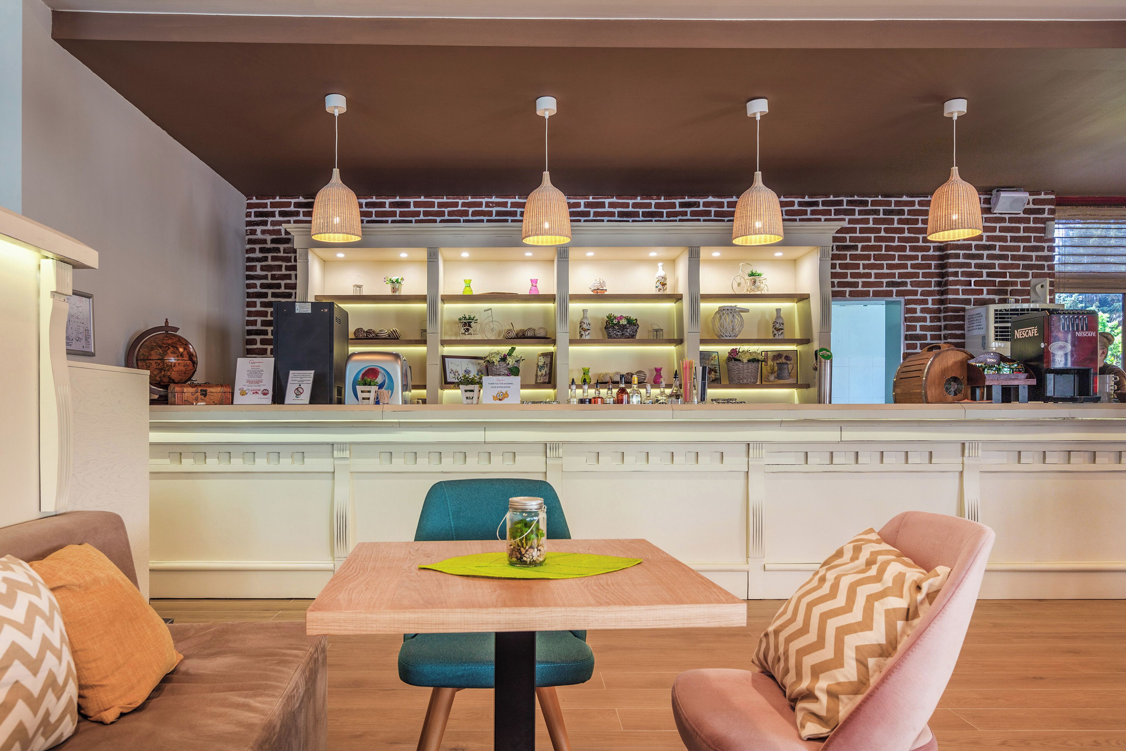 Une cuisine moderne avec un mur en briques, des luminaires suspendus et un comptoir sur lequel sont disposés divers objets.