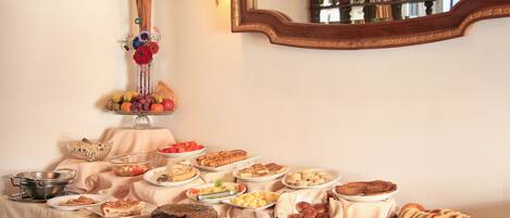 Une table de buffet garnie de divers plats et un vase rempli de fleurs.