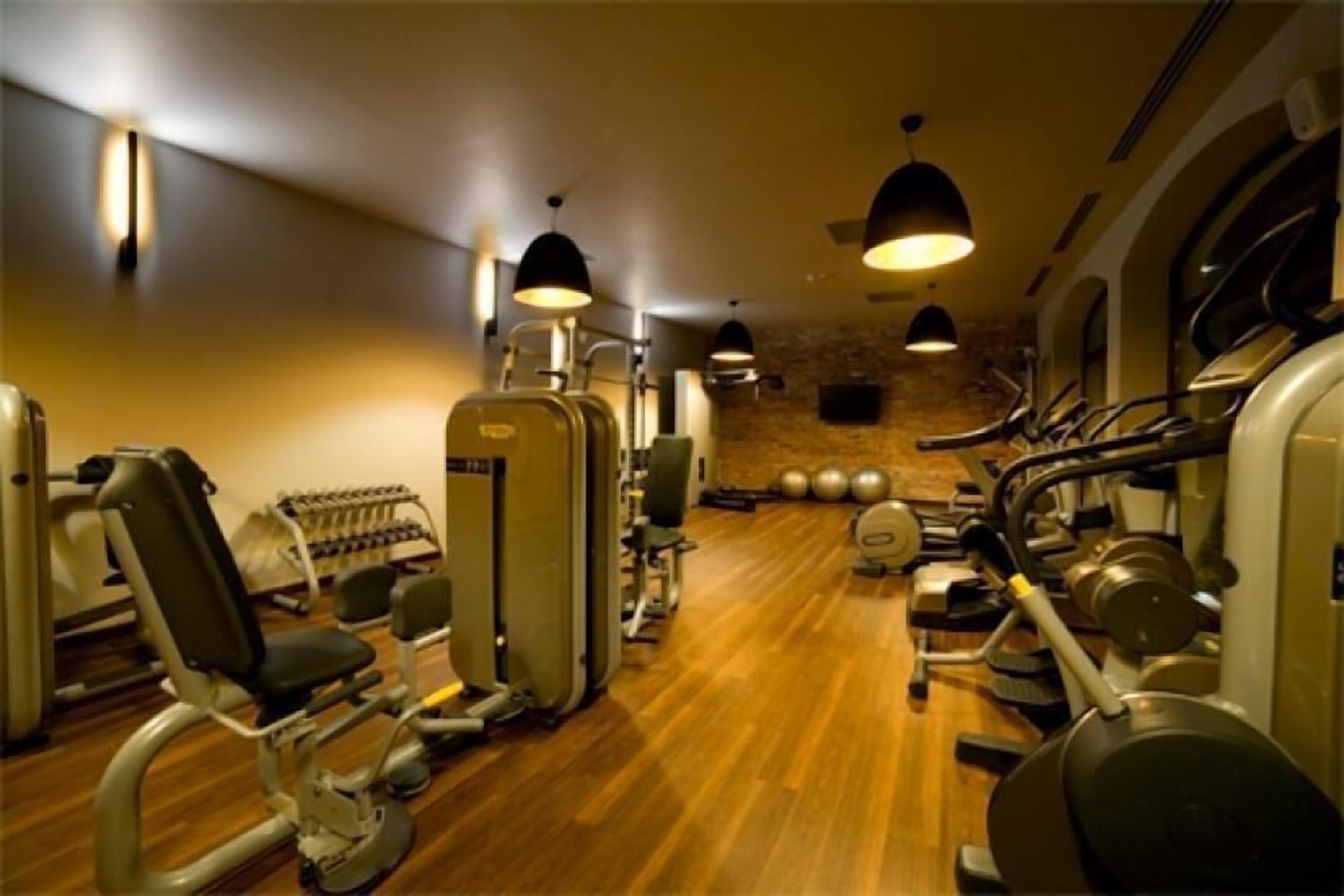 A gym with cardio machines, weight stations, and exercise balls.