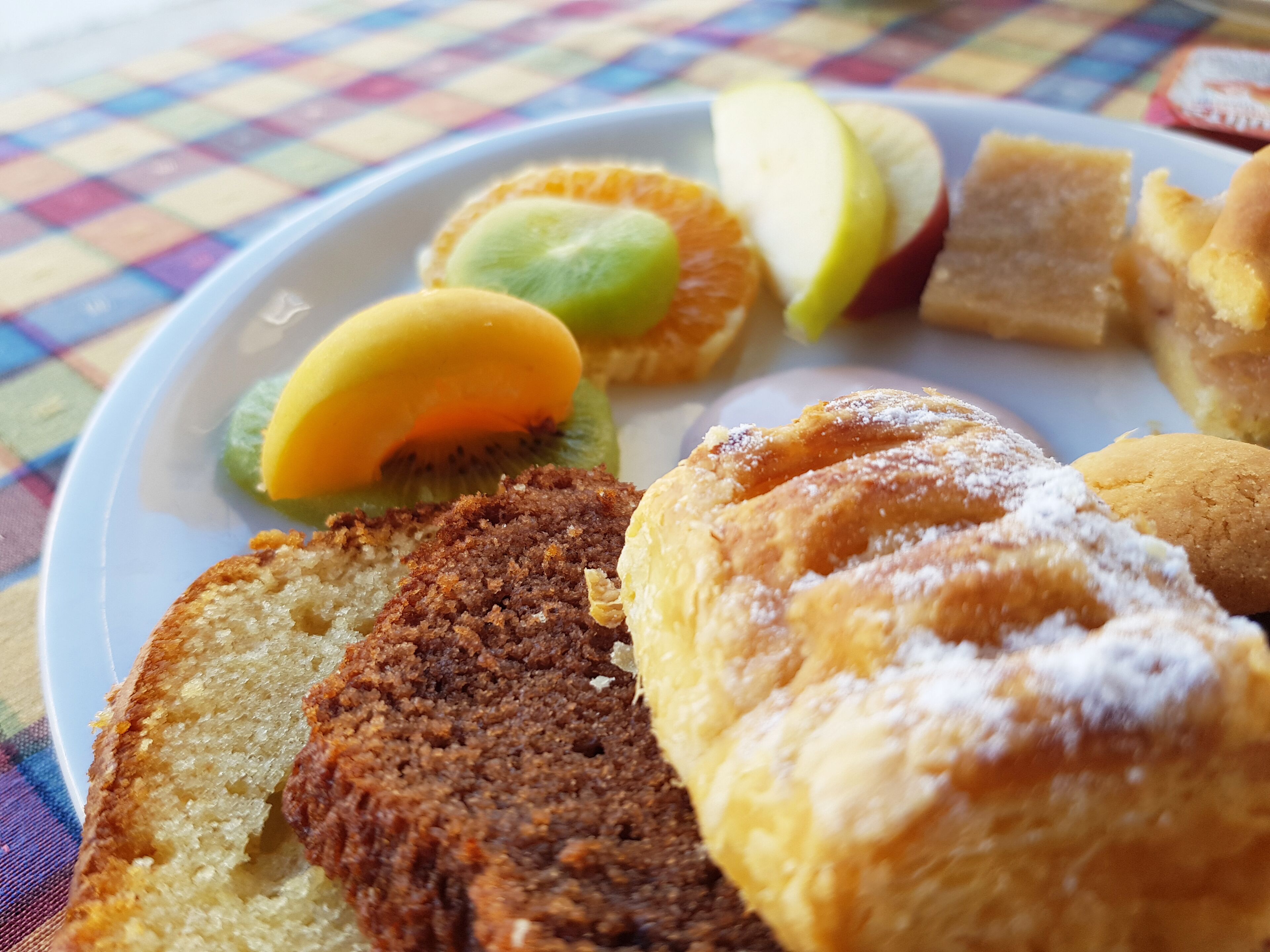 A plate with various pastries and fruits.