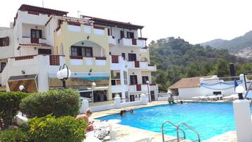 Enjoy a refreshing swim in the hotel's pool, surrounded by lush greenery and scenic hills.