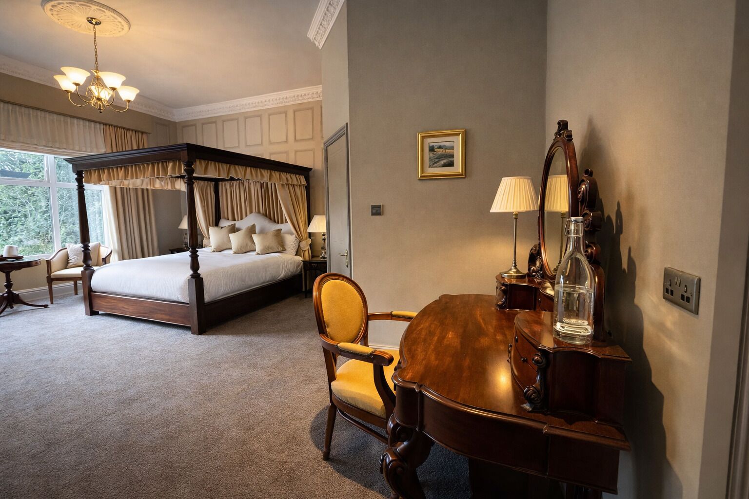 Una cama con dosel, un escritorio de madera con espejo y una silla en una habitación de hotel.
