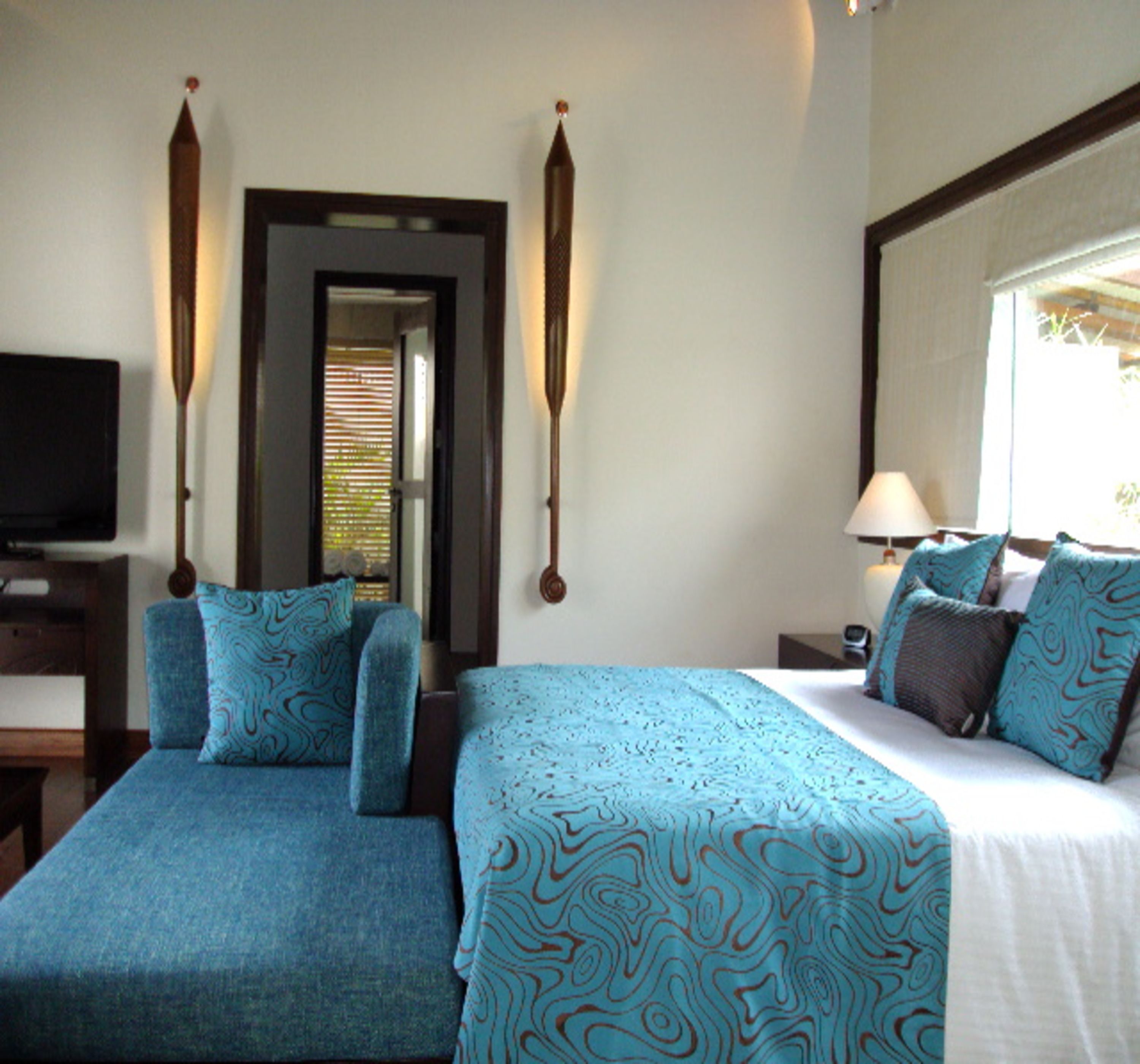 Habitación de hotel con dos camas, televisión, escritorio y ventana con vistas.