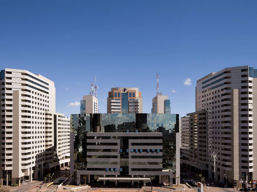 Um edifício moderno com um átrio central e edifícios altos ao redor.