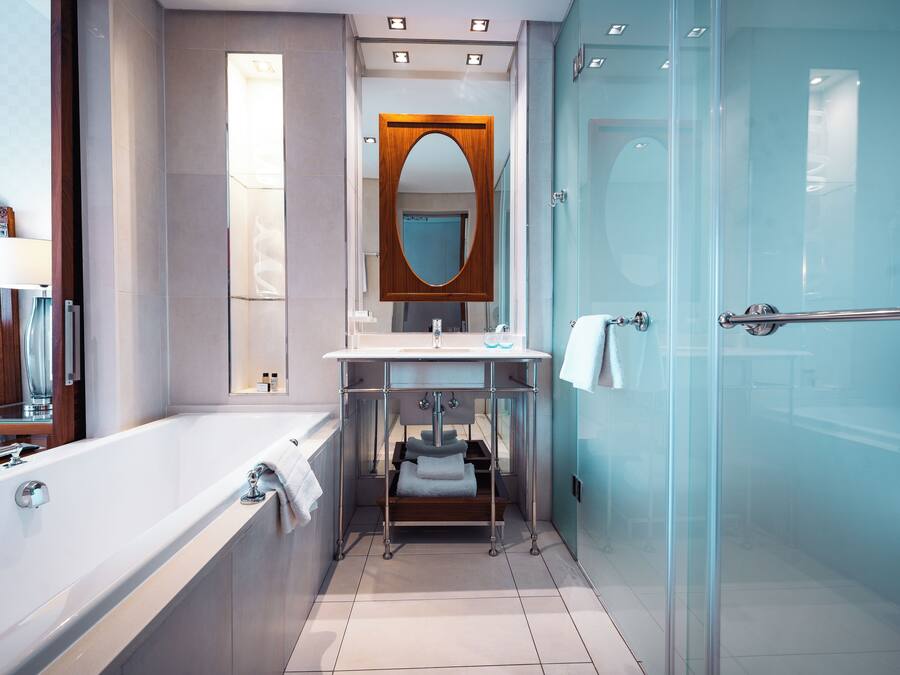 Un baño moderno con bañera, cabina de ducha de vidrio y tocador con espejo.