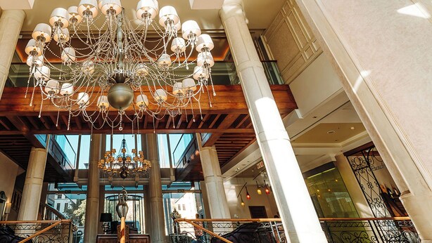 Een statige lobby met een grote kroonluchter, hoge plafonds en klassieke architectuur.