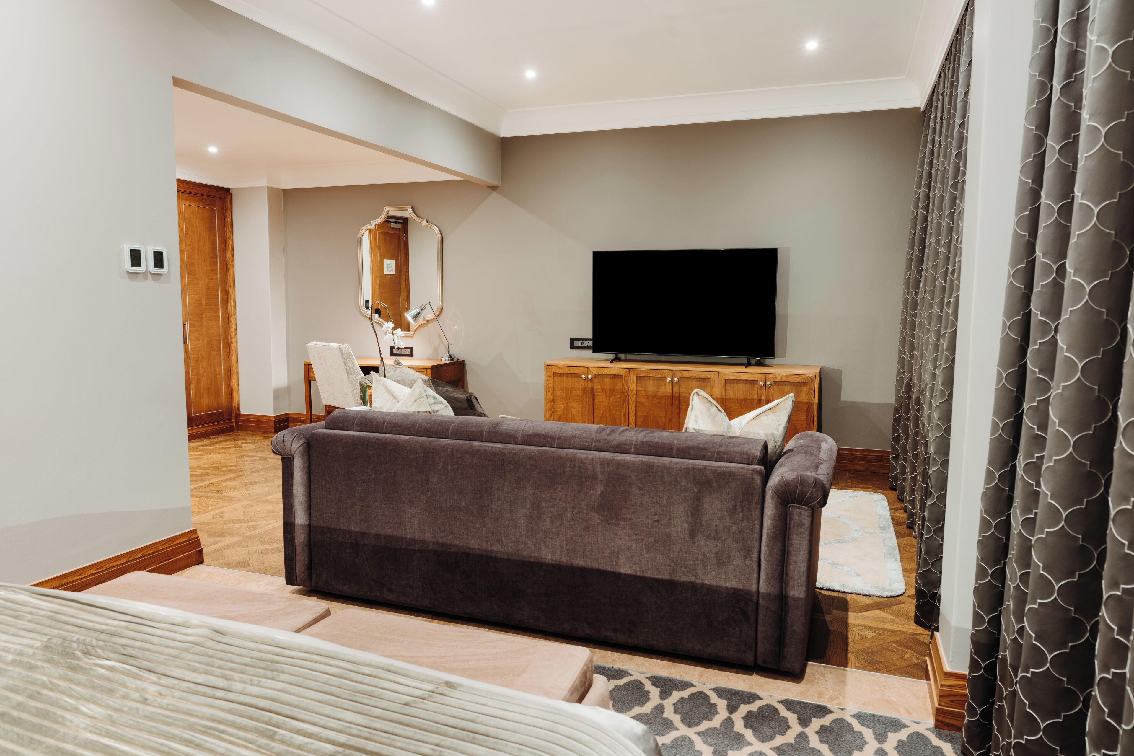 Uma sala de estar moderna com um sofá, uma televisão e um armário de madeira.