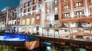 Een hotel met een zwembad, terras en een overdekte patio.