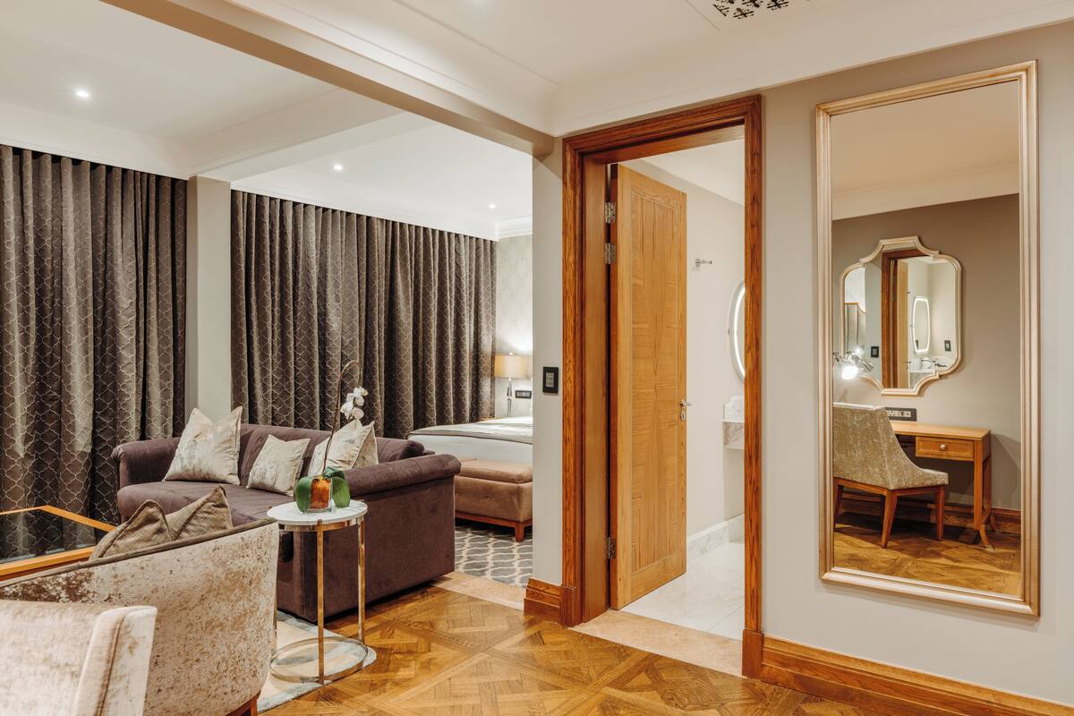 Una sala de estar moderna con un sofá, un sillón y una mesita con un jarrón.