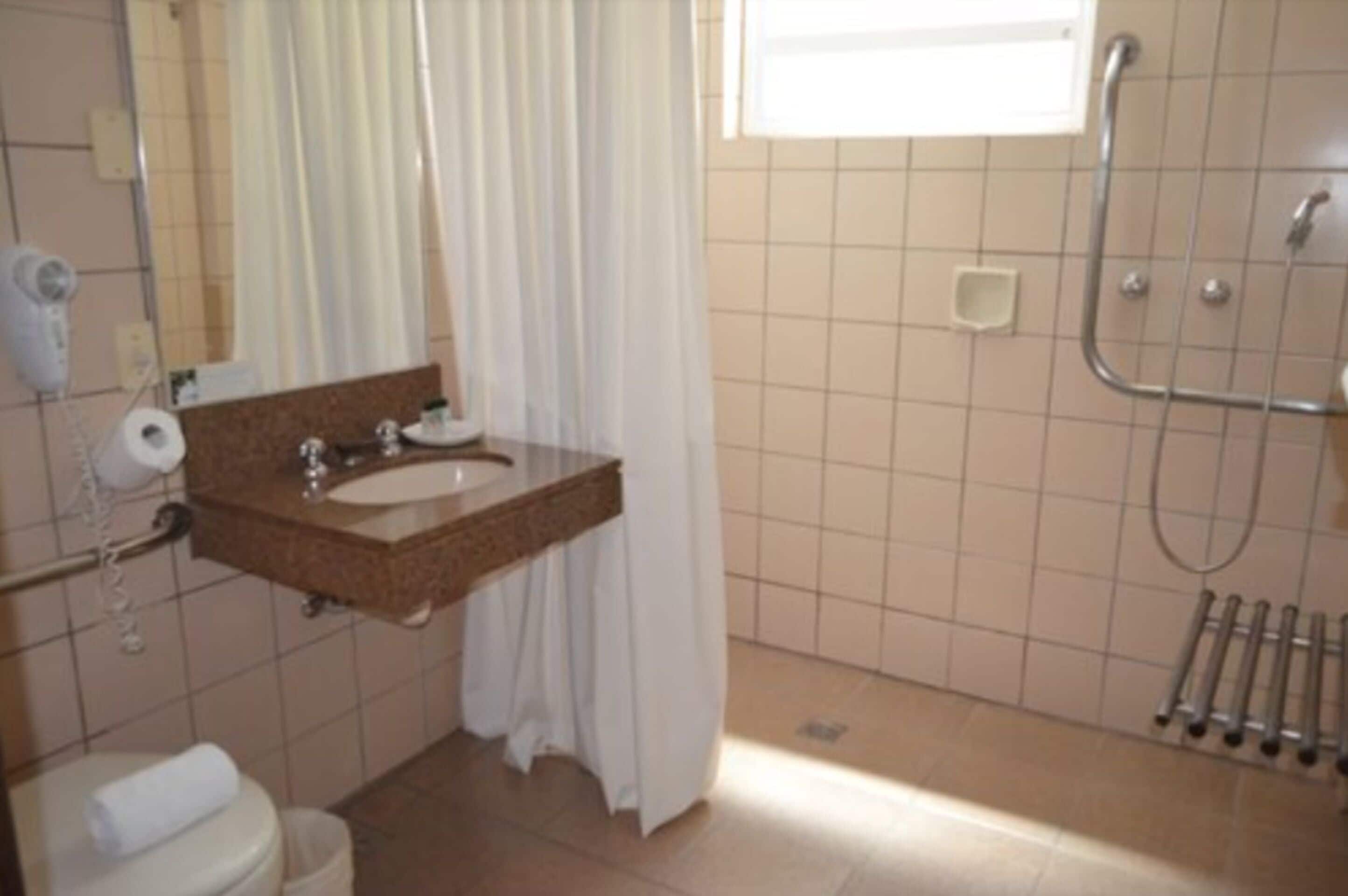 A bathroom with a sink, toilet, and shower.