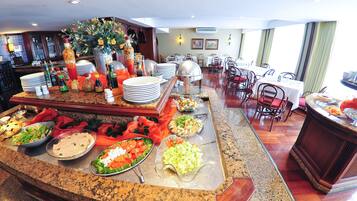 A buffet area with various dishes and a dining area with tables and chairs.