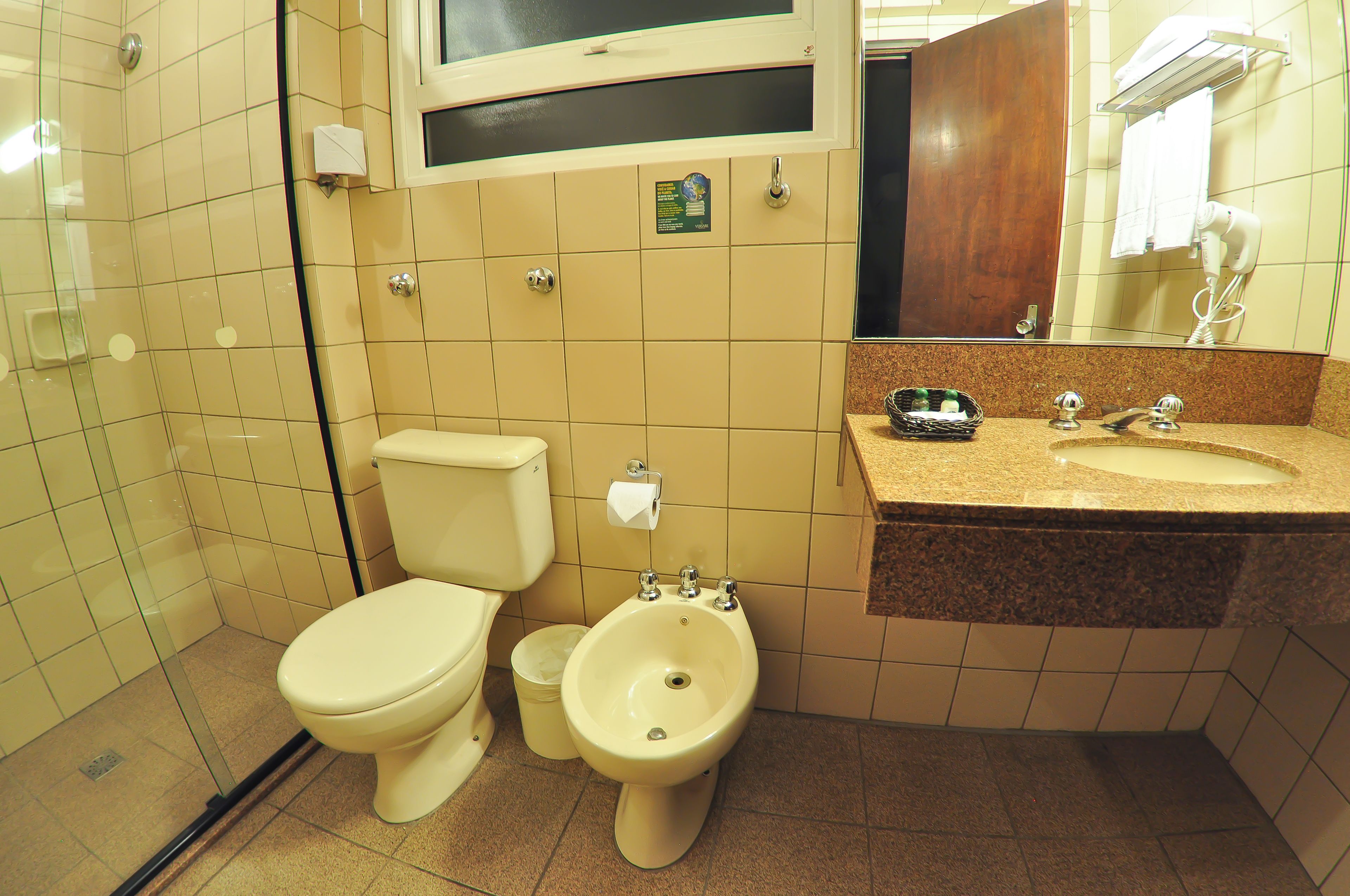 A bathroom with a toilet, bidet, and sink.