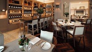 A modern dining area with a bar, wooden shelves with bottles, and a large window overlooking the room. - Las Alcobas, a Luxury Collection Hotel, Mexico City (Mexico City)
