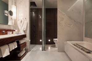 A modern bathroom with a glass shower enclosure, a white bathtub, and a vanity with a mirror and towel rack. - Las Alcobas, a Luxury Collection Hotel, Mexico City (Mexico City)