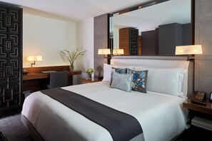 A hotel room with a large bed, bedside lamps, a desk with a chair, a mirror, and a vase with flowers. - Las Alcobas, a Luxury Collection Hotel, Mexico City (Mexico City)