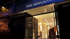 A modern building entrance with a glass door, a visible staircase inside, and a sign above the door. - Las Alcobas, a Luxury Collection Hotel, Mexico City (Mexico City)