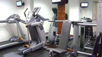A gym with treadmills, elliptical machines, and weightlifting equipment.