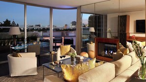 A modern living room with a sofa, armchairs, a glass coffee table, and a fireplace. - Las Alcobas, a Luxury Collection Hotel, Mexico City (Mexico City)