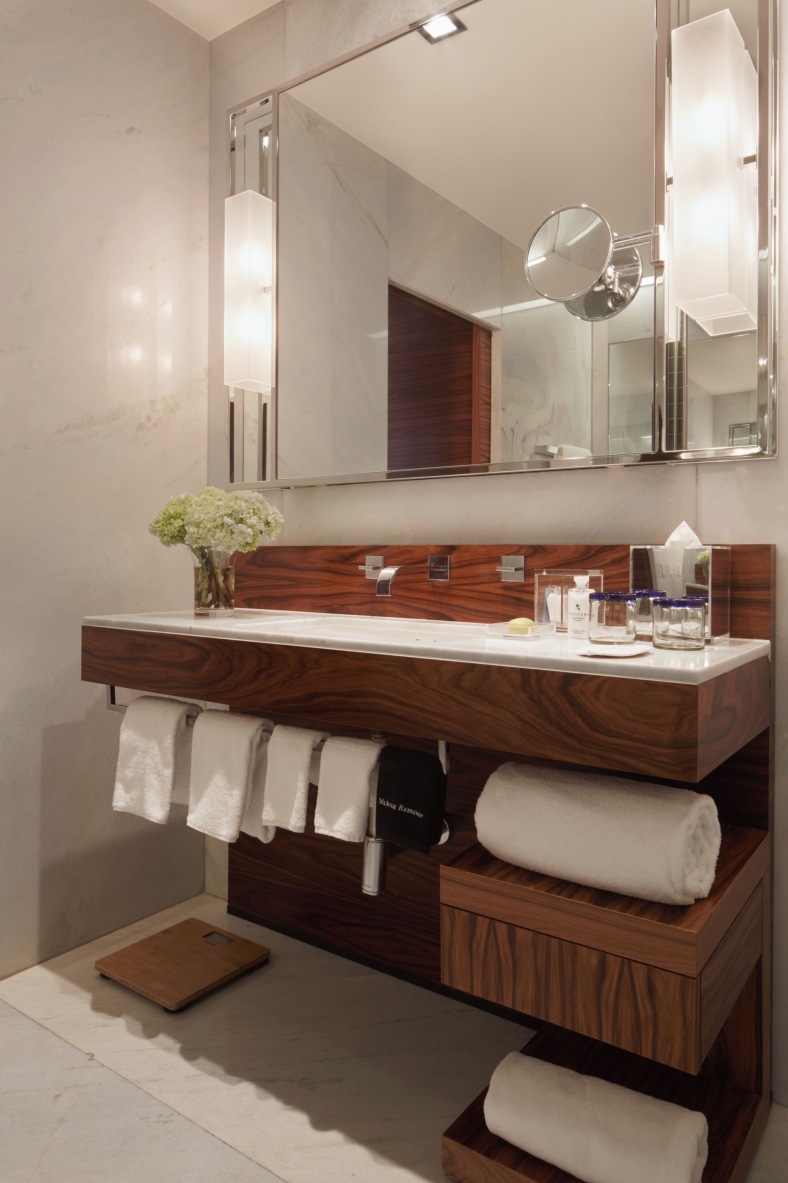 Une salle de bain moderne avec un meuble-lavabo en bois, un grand miroir et un porte-serviettes.