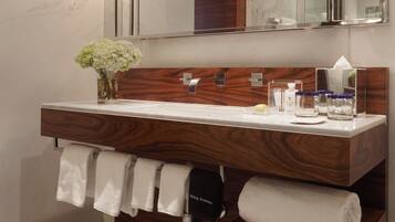 Une salle de bain moderne avec un meuble-lavabo en bois, un grand miroir et un porte-serviettes.