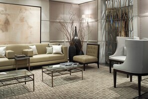 A modern living room with a beige sofa, two armchairs, a glass coffee table, and a decorative vase. - Las Alcobas, a Luxury Collection Hotel, Mexico City (Mexico City)