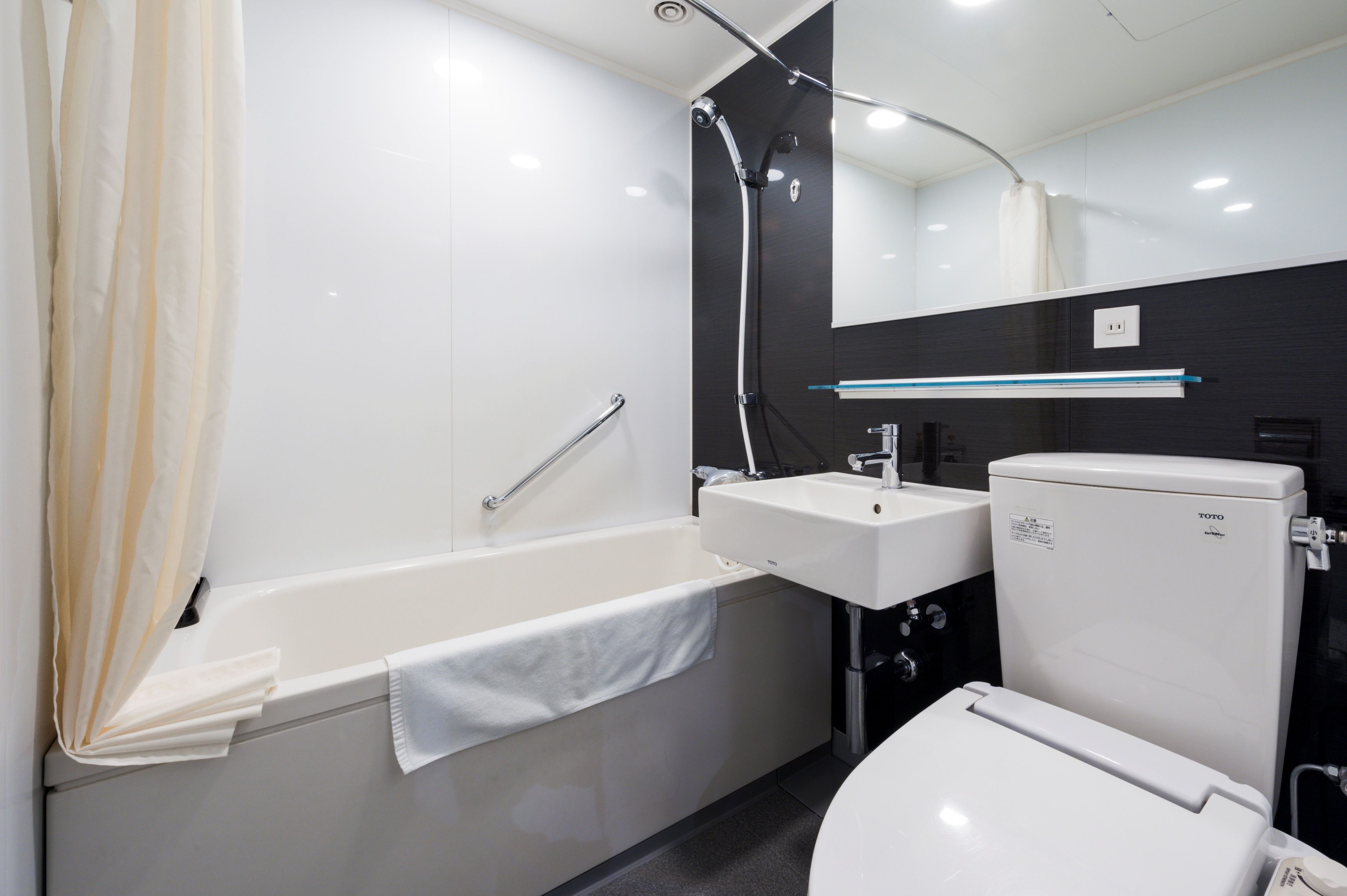 A modern bathroom with a bathtub, a sink, and a toilet.