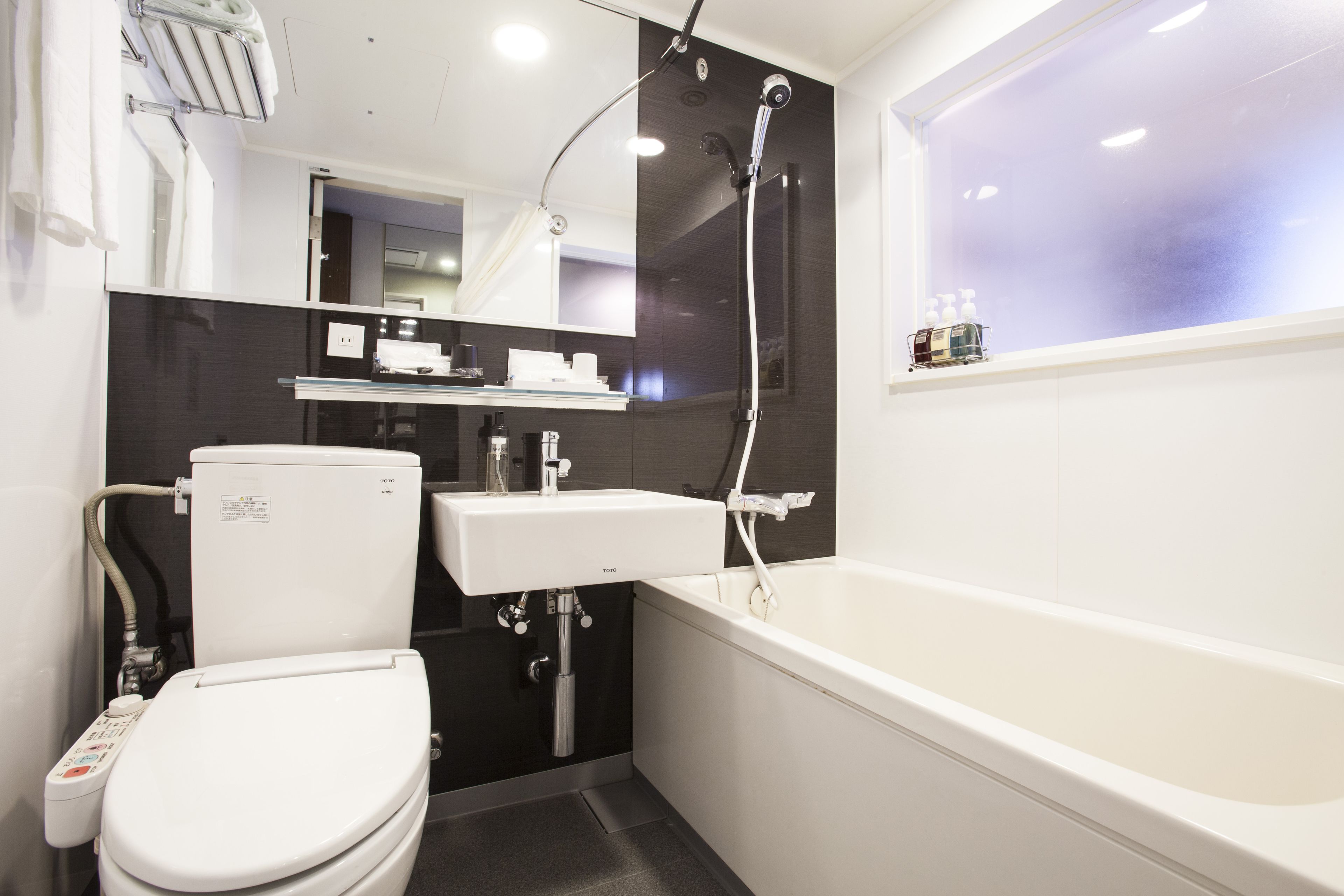 Un baño moderno con inodoro, lavamanos y bañera.
